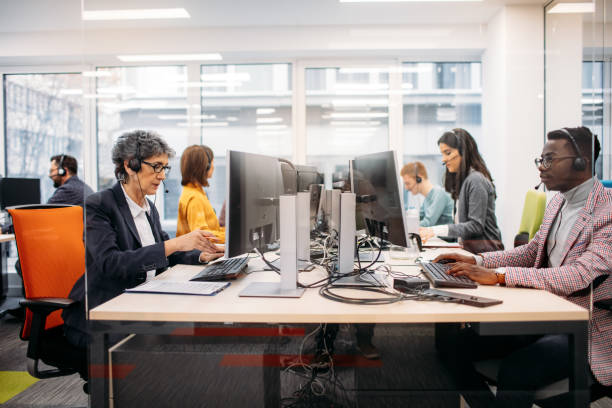 Call Center Workers Call Center Workers in Their Office. Sitting by the desk and working. incidental people stock pictures, royalty-free photos & images