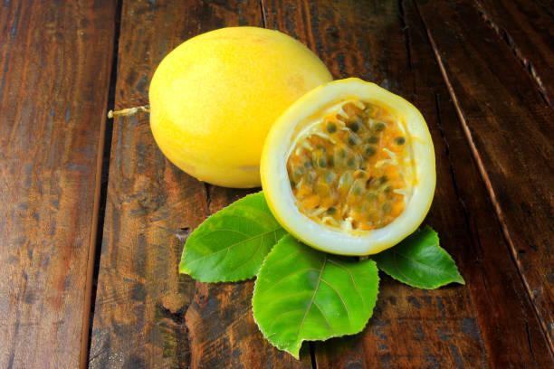 istock yellow passion fruit with leaf and passion fruit cut in half on wooden table. Close-up 1079626208