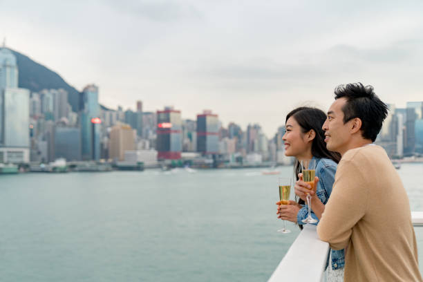 하버 시티에서 홍콩 스카이라인의 전망을 즐기는 젊은 부부 - champagne lifestyles couple friendship 뉴스 사진 이미지
