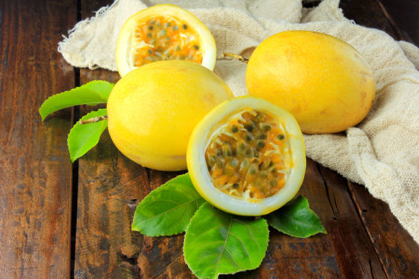 istock yellow passion fruit with leaf on sack and passion fruit cut in half on wooden table. Close-up 1079626318