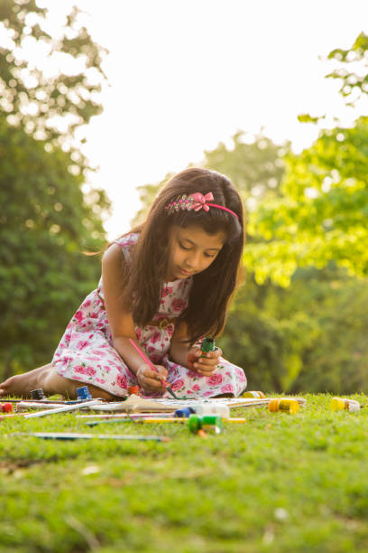istock girl drawing during spring day in nature. - Stock image 1079627144
