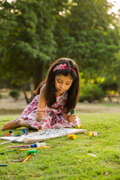 istock girl drawing during spring day in nature. - Stock image 1079634756