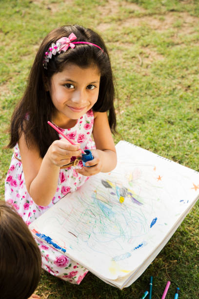 istock girl drawing during spring day in nature. - Stock image 1079635004