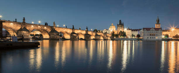 Panorama Prag Charles Bridge Vltava River at Twilight Panorama of the famous illuminated Charles Bridge (Karluv Most) reflecting in the Vltava River at Twilight. Edited Colors. Prague, Czech Republic, Europe. prague skyline panoramic scenics stock pictures, royalty-free photos & images