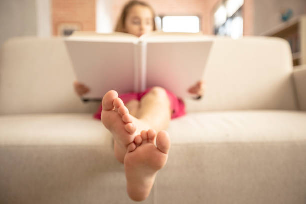 Low Section Of Baby Lying On Bed
