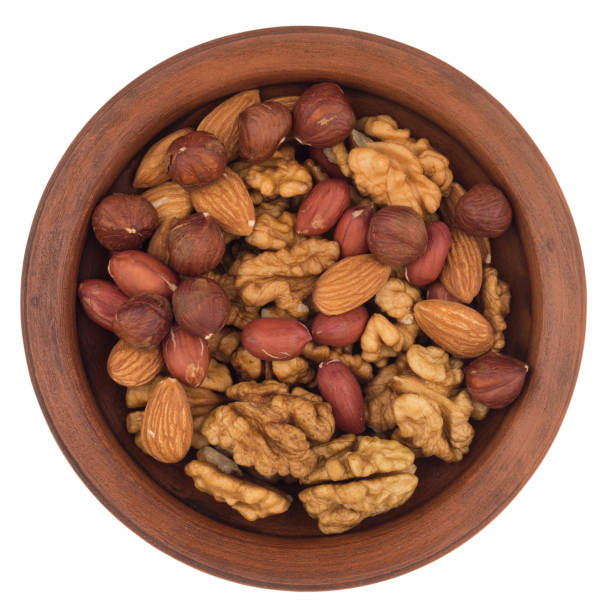 istock Mixture of nuts in a ceramic bowl isolated on white background. Top view 1079648936