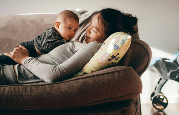 istock Woman lying on couch with her baby 1079650536