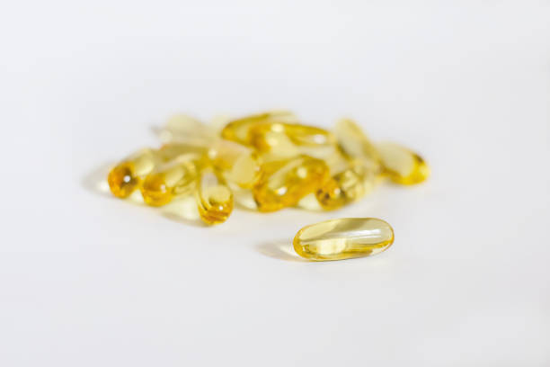 gelb transparent kapseln auf weißem hintergrund - capsule gel effect pill vitamin pill stock-fotos und bilder