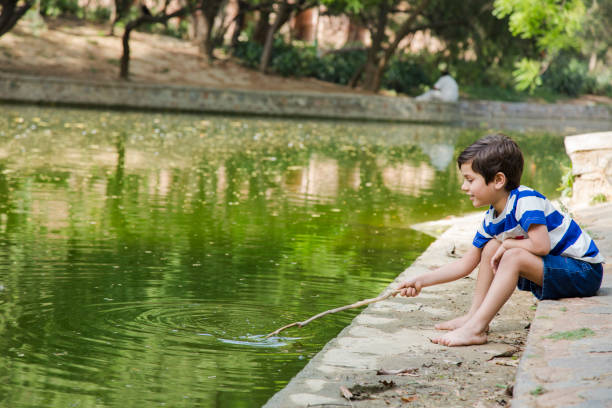 Nine year old boy feeding water birds