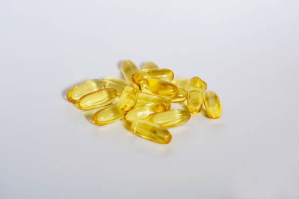 gelb transparent kapseln auf weißem hintergrund - capsule gel effect pill vitamin pill stock-fotos und bilder