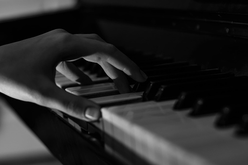 Hands on the keys of a piano