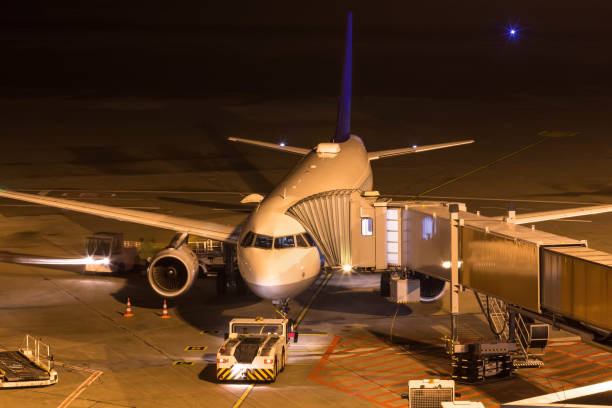 istock an airplane at night at an airport gate 1079672914