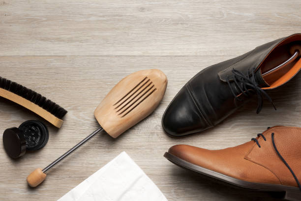 shoe care of leather men's shoes and boots Top view of two leather men's shoe and boot with a shoe tree and items for shoe care room for text shoe polish stock pictures, royalty-free photos & images