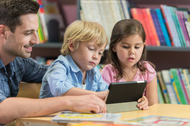 istock Male Teacher With His Students In Library 1079676410
