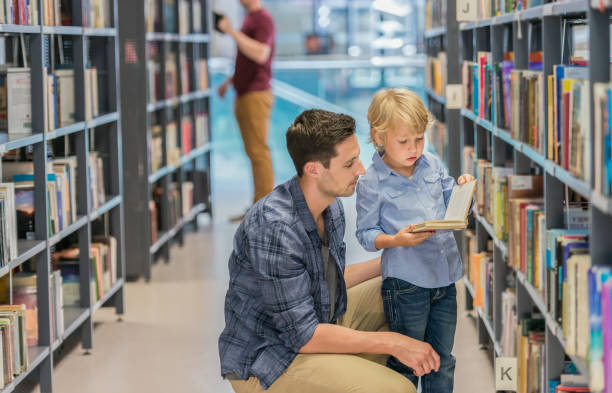 Preschool Boy With His Father In Public Library stock photo
