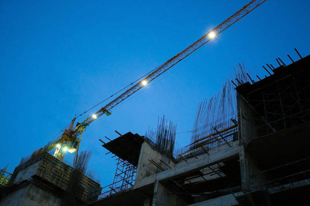 construction site with crane working in the night - tower steel mansion investment imagens e fotografias de stock