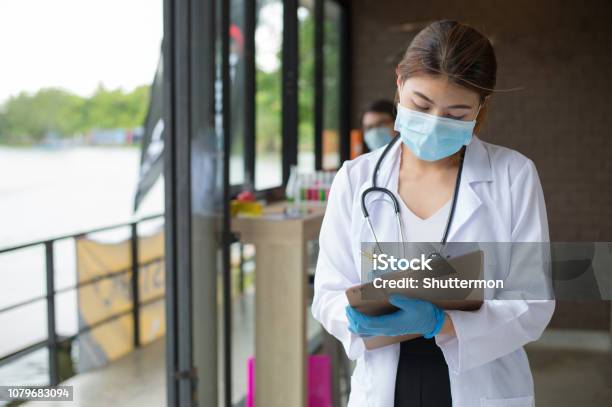 Woman Doctor With Stethoscope And Blue Glove Write Report By Pencil In A Paper Stock Photo - Download Image Now