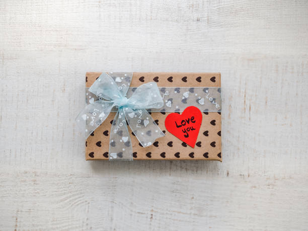 Box with a gift, tied with a ribbon, note with sweet words