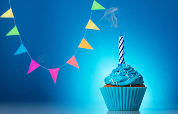istock Festive cupcake with candle on blue background 1079689806