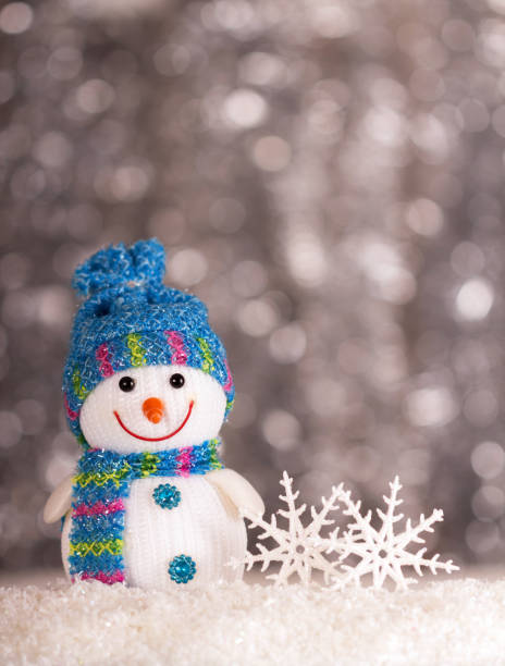 istock Smiling snowman and snowflakes on gray background with bokeh effect 1079690334
