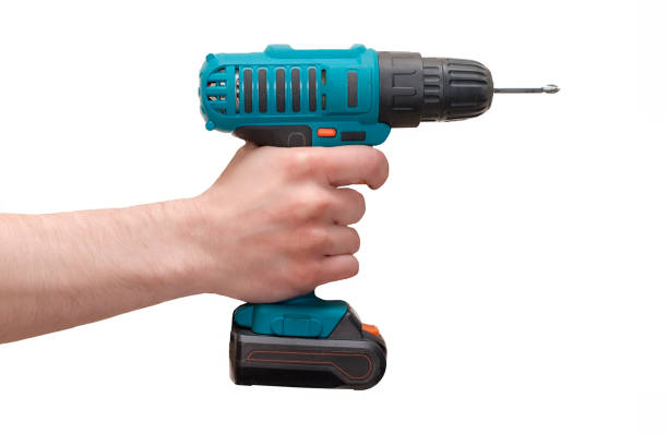 istock Hand holds cordless electric screwdriver with bit for screws isolated on white background 1079696034