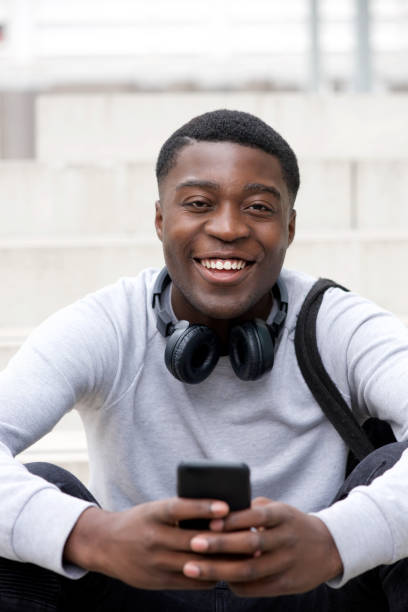istock cool young black man smiling with cellphone and headphones 1079696144
