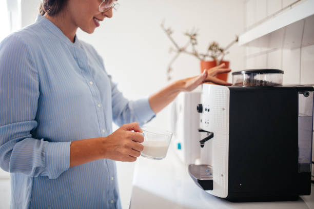 Good start of the day Woman preparing coffee at home in early morning coffee maker in kitchen stock pictures, royalty-free photos & images