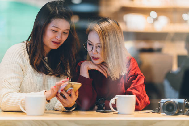 istock Two Asian female friends chatting in cafe 1079713524