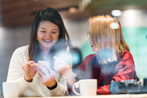 istock Two Asian female friends chatting in cafe 1079714096
