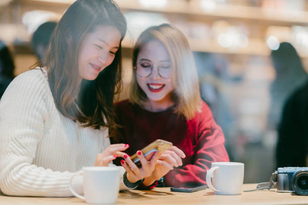 istock Two Asian female friends chatting in cafe 1079714752