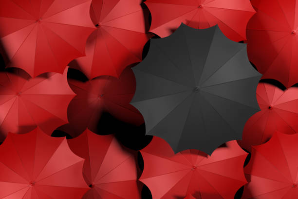 istock Black umbrella standing out from the red color umbrella crowd. 1079717340