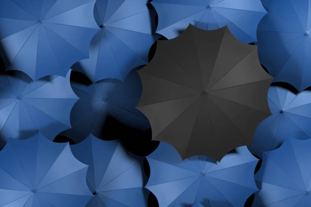 istock Black umbrella standing out from crowd. 1079717530