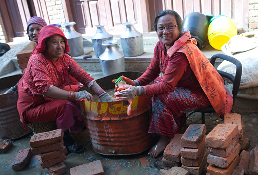 Bhaktapur, Nepal - January 23, 2017: Nepalese women washing bricks in building site after the earthquake damage in Kathmandu valley