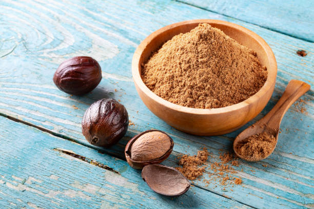 istock Whole inshell nuts, cracked and nutmeg powder on old blue rustic background. 1079733014
