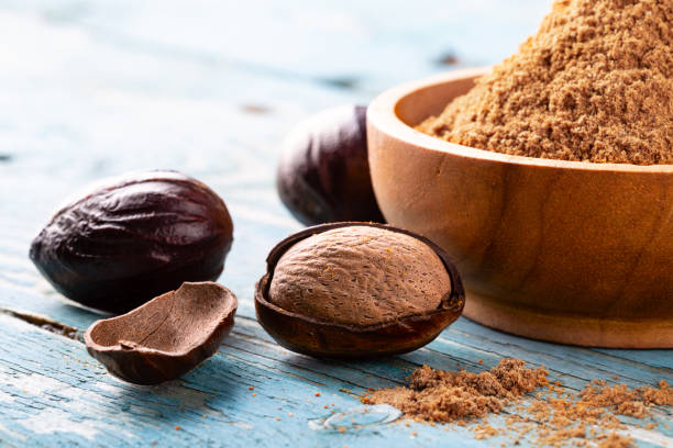 istock Whole inshell nuts, cracked and nutmeg powder on old blue rustic background. 1079733056