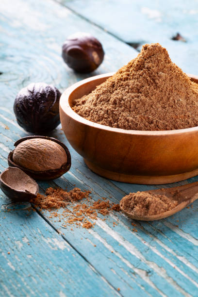 istock Whole inshell nuts, cracked and nutmeg powder on old blue rustic background. 1079733070