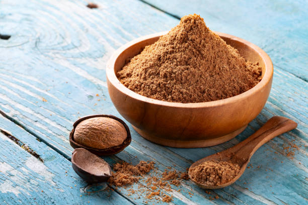istock Whole inshell nuts, cracked and nutmeg powder on old blue rustic background. 1079733104