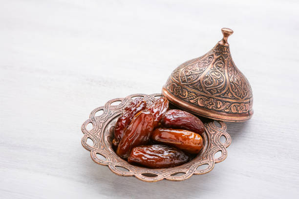 istock Plate of pitted dates on a white wooden background. 1079743902