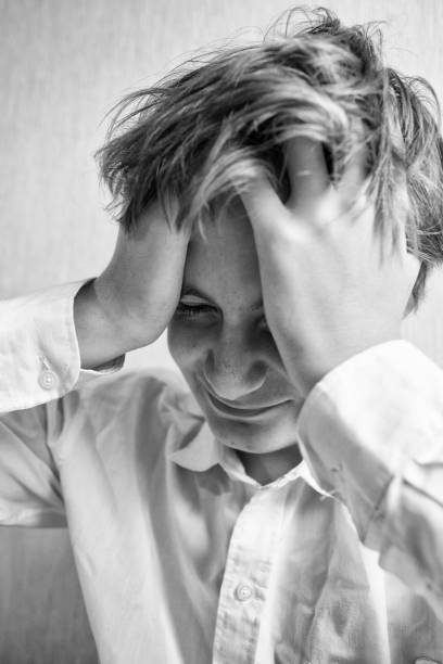 istock Teenager boy squeezes his head 1079748020