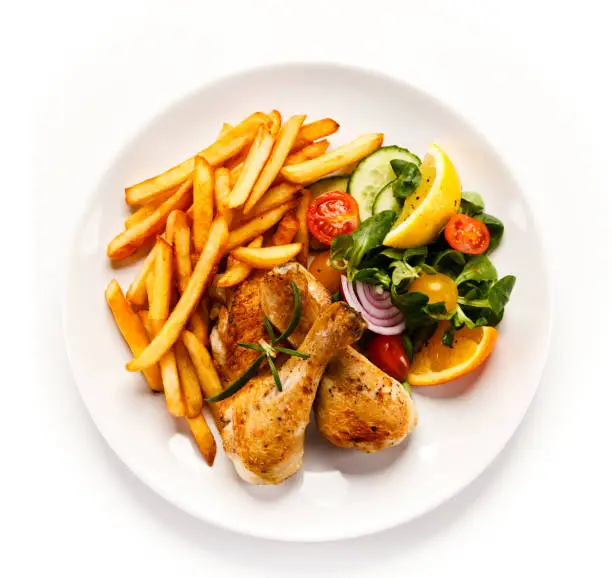 Photo of Roasted chicken drumsticks, French fries and vegetables