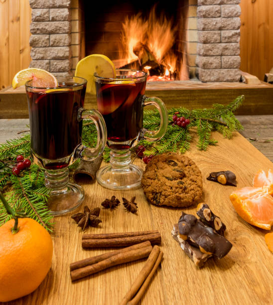 istock Mulled wine glintwine in drinking glasses and christmas decorations, against cozy fireplace background. 1079756434