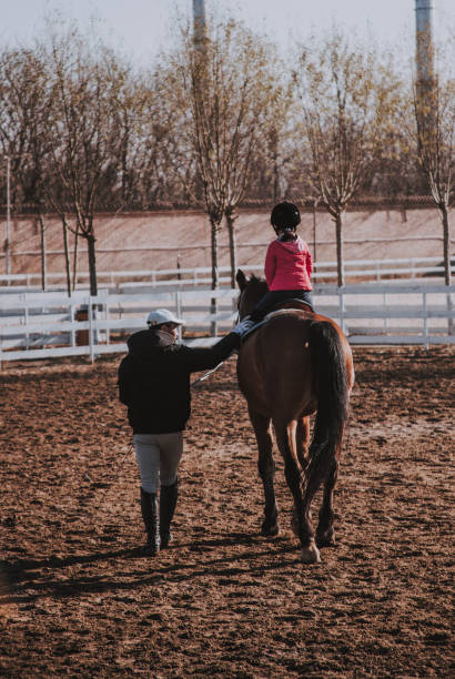 istock Little asian girl taking a riding lesson 1079763740
