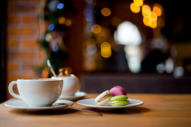 istock Cappuccino coffee in white cup with colorful macaroons served on wooden table 1079767516