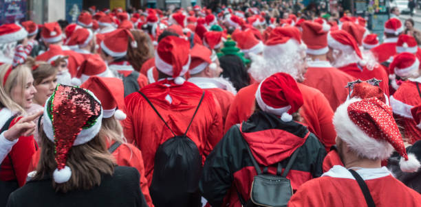 Santacon event in London London, UK - December 2018 : Group of people dressed in santa outfits and taking part in a themed SantaCon event brixton photos stock pictures, royalty-free photos & images