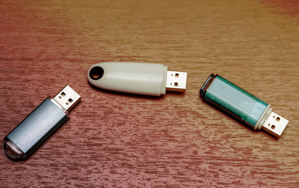 Three USB flash drives. Three USB flash drives are located on a wooden surface. wooden flash drive stock pictures, royalty-free photos & images