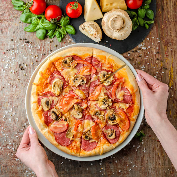 istock Woman hands takes pizza on a plate, top view 1079775038