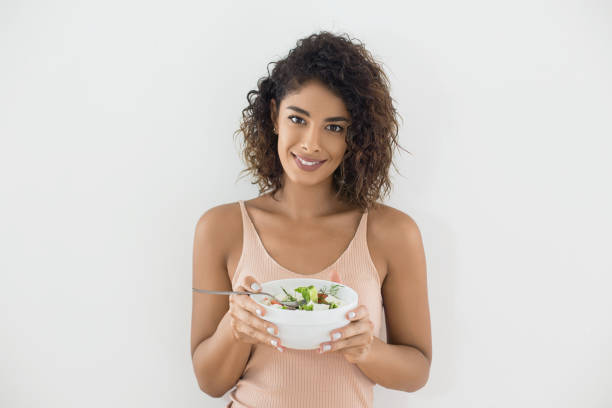 istock Smiling young woman eats salad 1079794732
