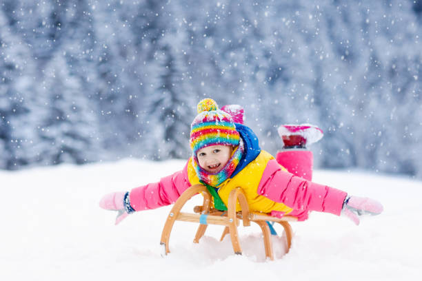 istock Girl on sleigh ride. Child sledding. Kid with sledge 1079799586