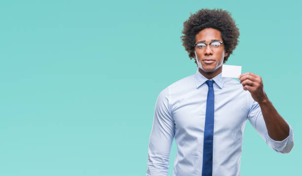 istock Afro american man holding visit card over isolated background with a confident expression on smart face thinking serious 1079800152