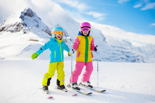 narty i śnieżna zimowa zabawa dla dzieci. dzieci jeżdżą na nartach. - winter child coat baby girls zdjęcia i obrazy z banku zdjęć
